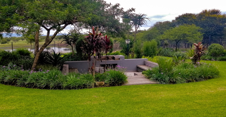 Stylish outdoor seating area with wooden deck and garden views in a Durban landscape by Creative Landscapes