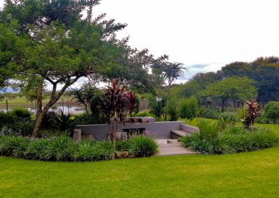 Stylish outdoor seating area with wooden deck and garden views in a Durban landscape by Creative Landscapes