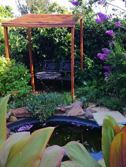 View of completed backyard putting green with surrounding landscaping in Durban, designed by Creative Landscapes